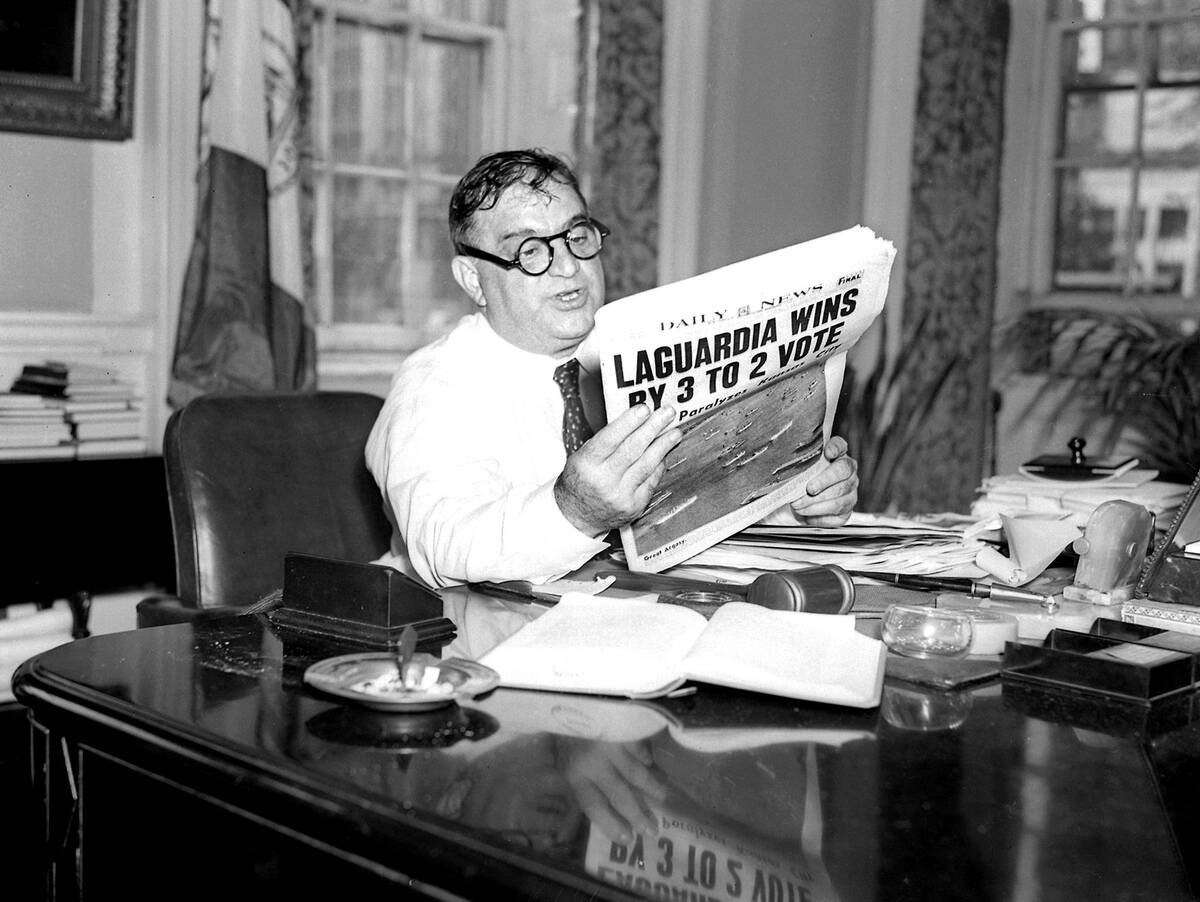 Mayor Fiorello LaGuardia reading the Daily News election res