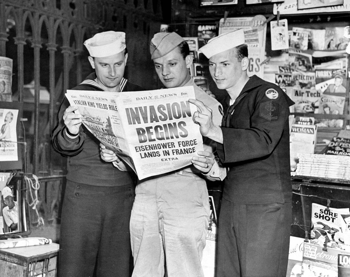 Navy, Army and Merchant Marine servicemen read the Daily New