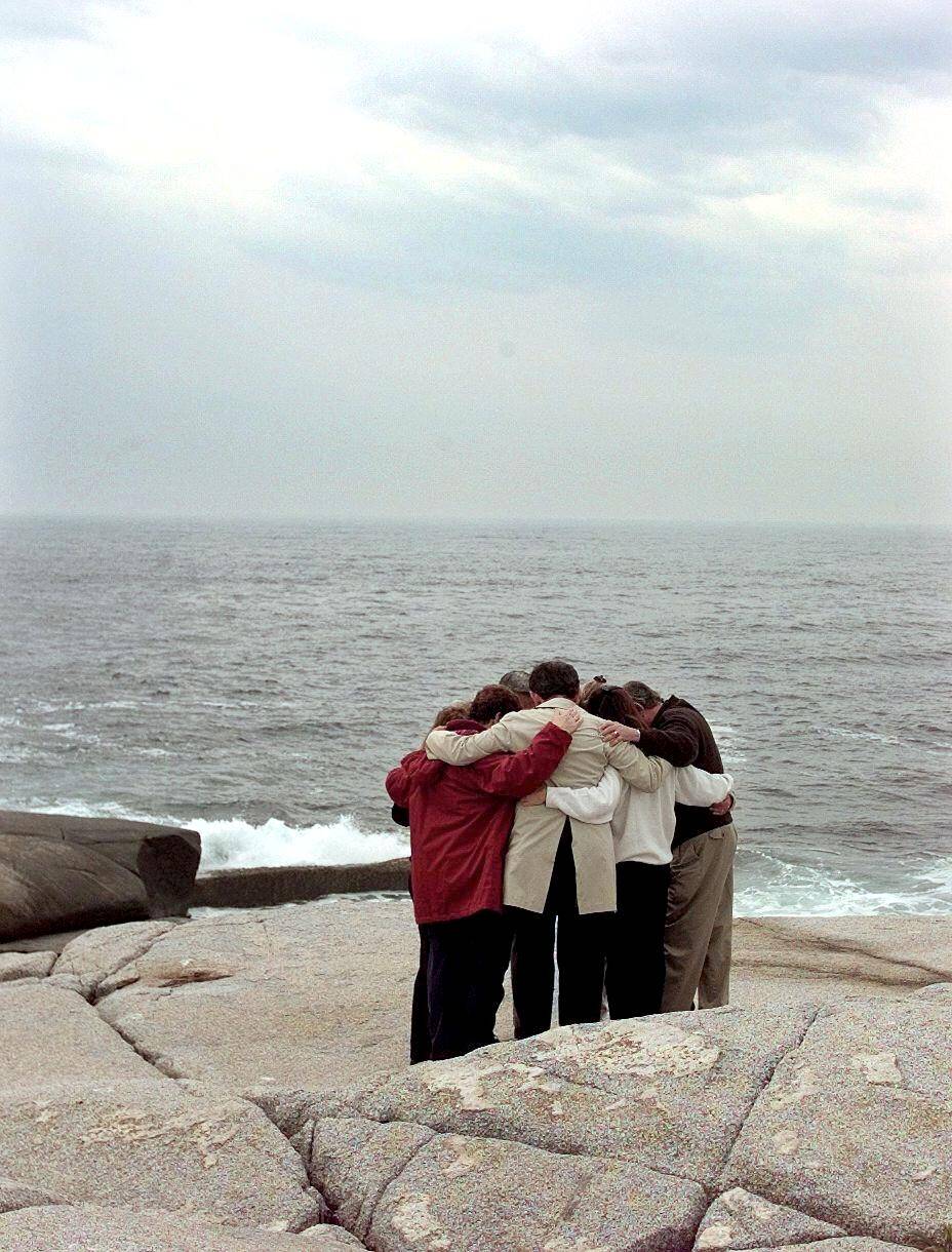 Relatives of Swissair crash victims hug on the roc