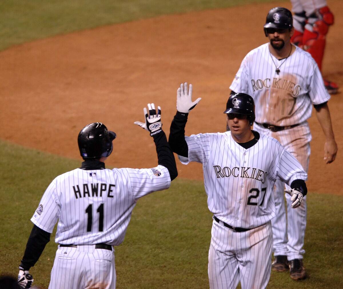 Garrett Atkins of the Colorado Rockies, No. 27, is congratul
