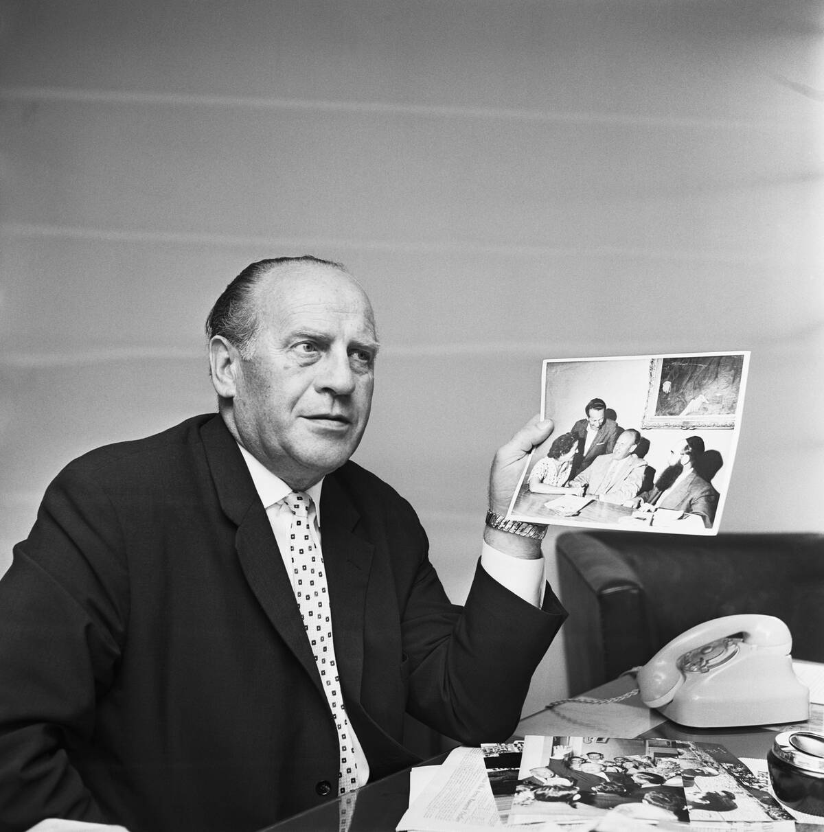 Oskar Schindler Hold Photos of Holocaust