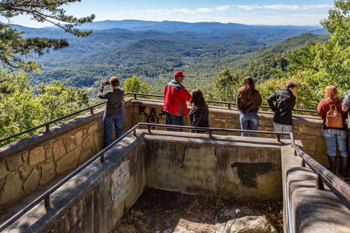 Woman using cell phone to take photo at a scenic overlook along the Foothills Parkway near Wears Valley, Tennessee in the Great Smoky Mountains National Park