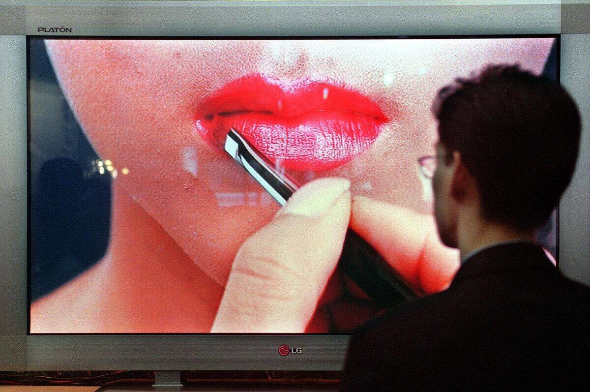 A South Korean man watches a cosmetics model shown