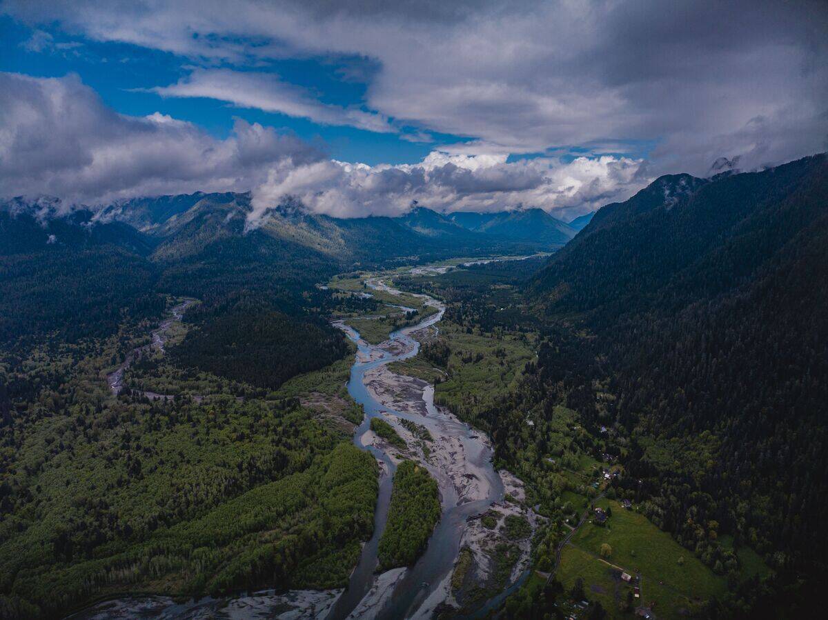 Aerial view of snow capped mountains and river leading to Olympic National Park, Washington State