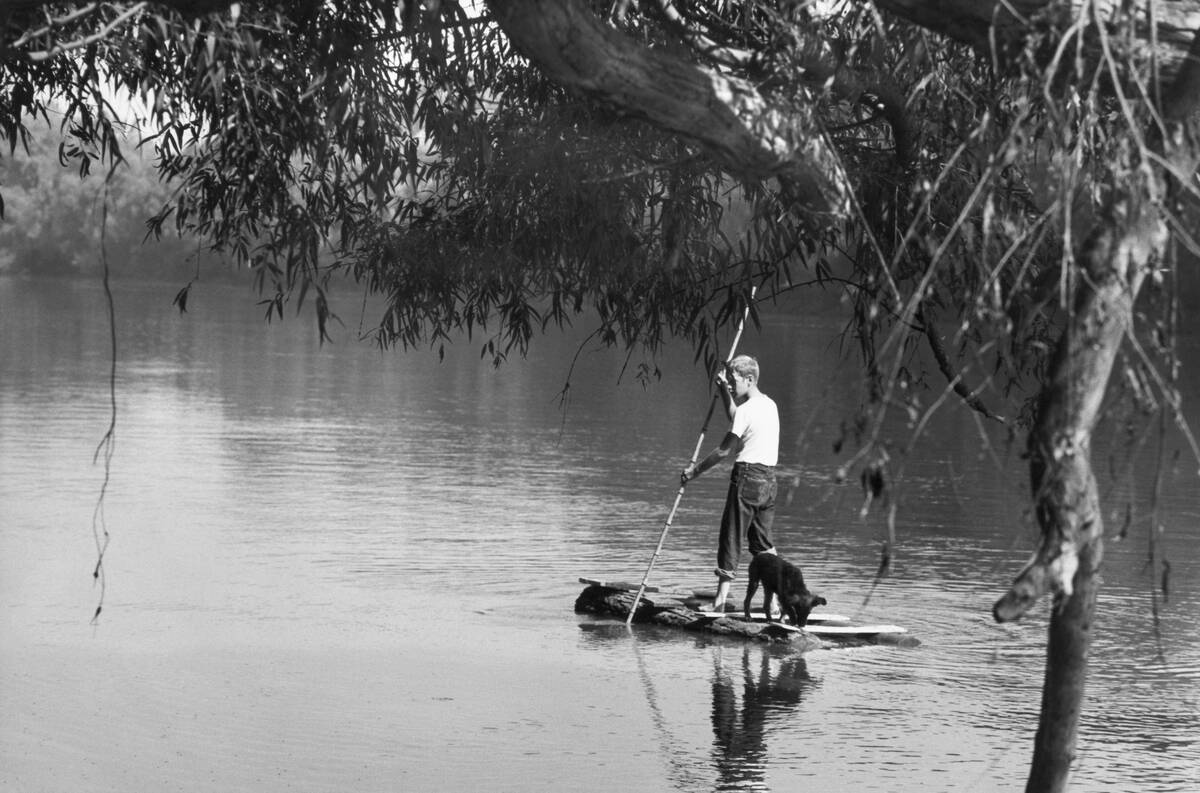 Boy on a Makeshift Raft with His Dog