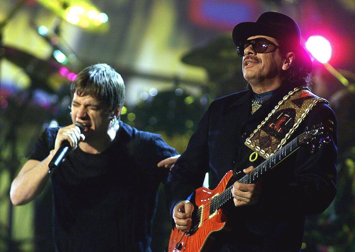 Carlos Santana (R) and Rob Thomas perform during t