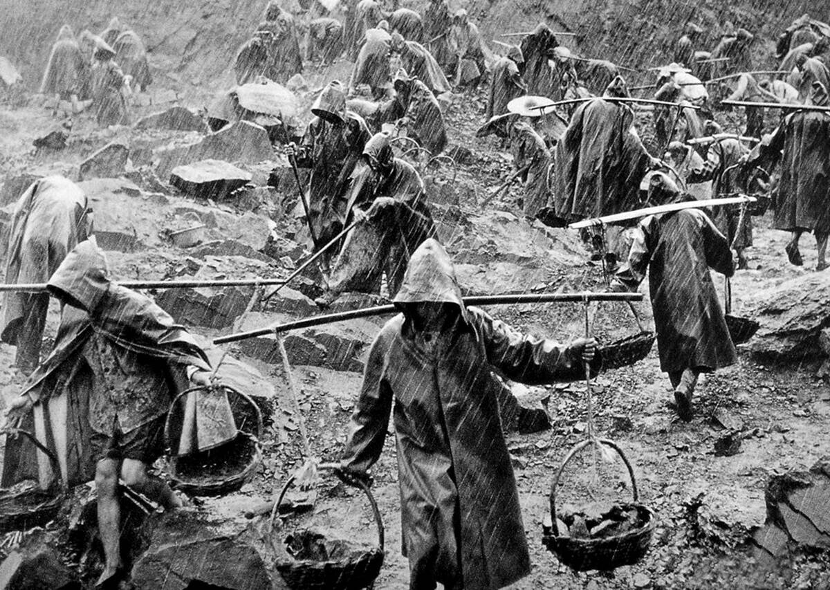 China: A team of workers labouring in a stone quarry in heavy rain during the 'Great Leap Forward' (1959 - 1961)