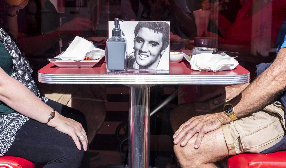 Couple sitting in diner with photo of Elvis on table in Whitby in England.