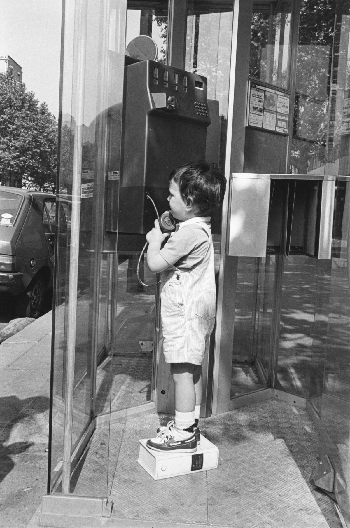 Enfant utilisant un téléphone public