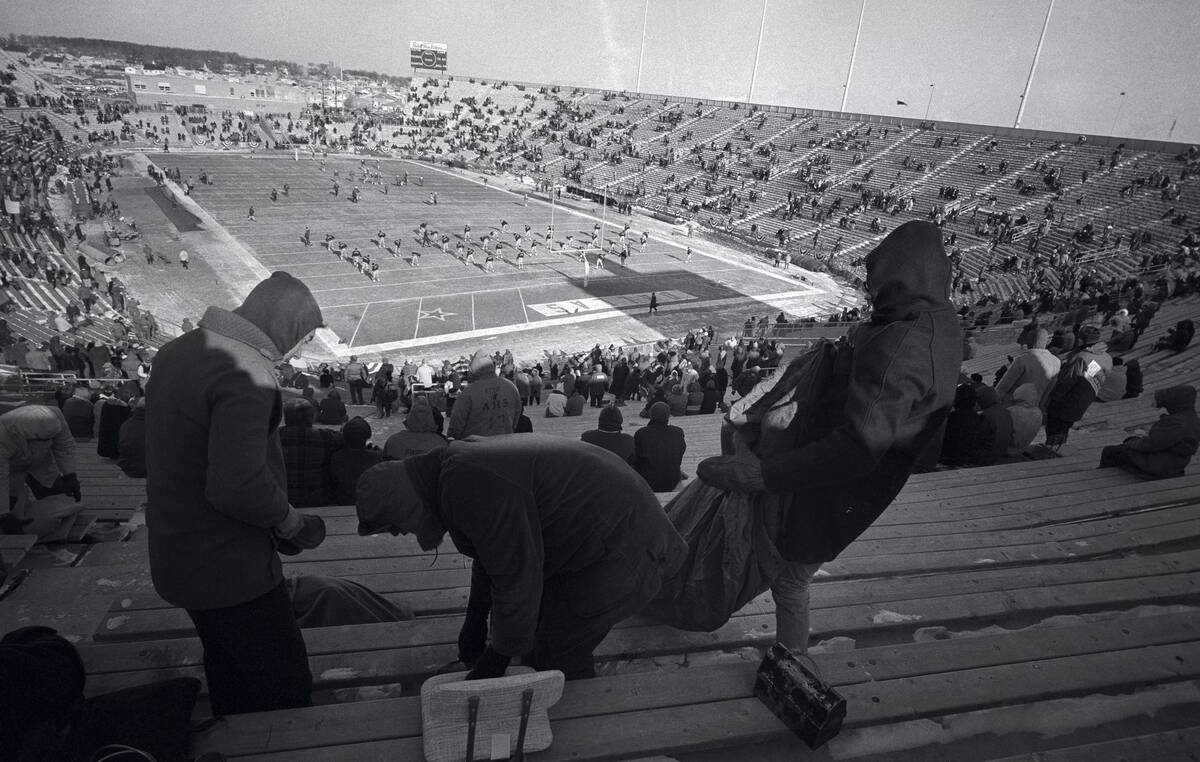 Fans Brushing Snow Off Seats at Stadium