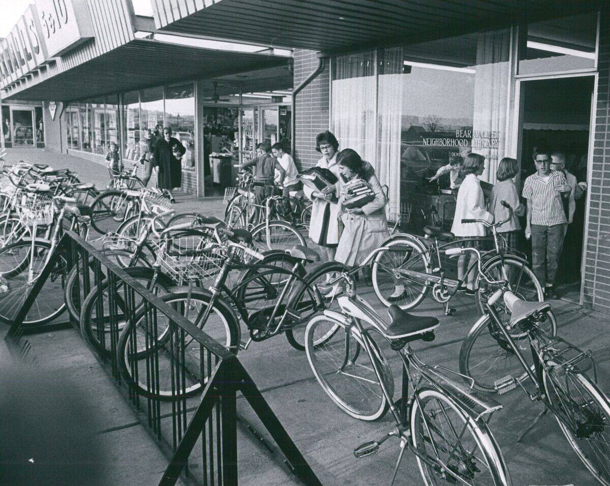 FEB 23 1963, MAR 6 1963; Bicycles crowd sidewalk in front of branch library in shopping center. Chil