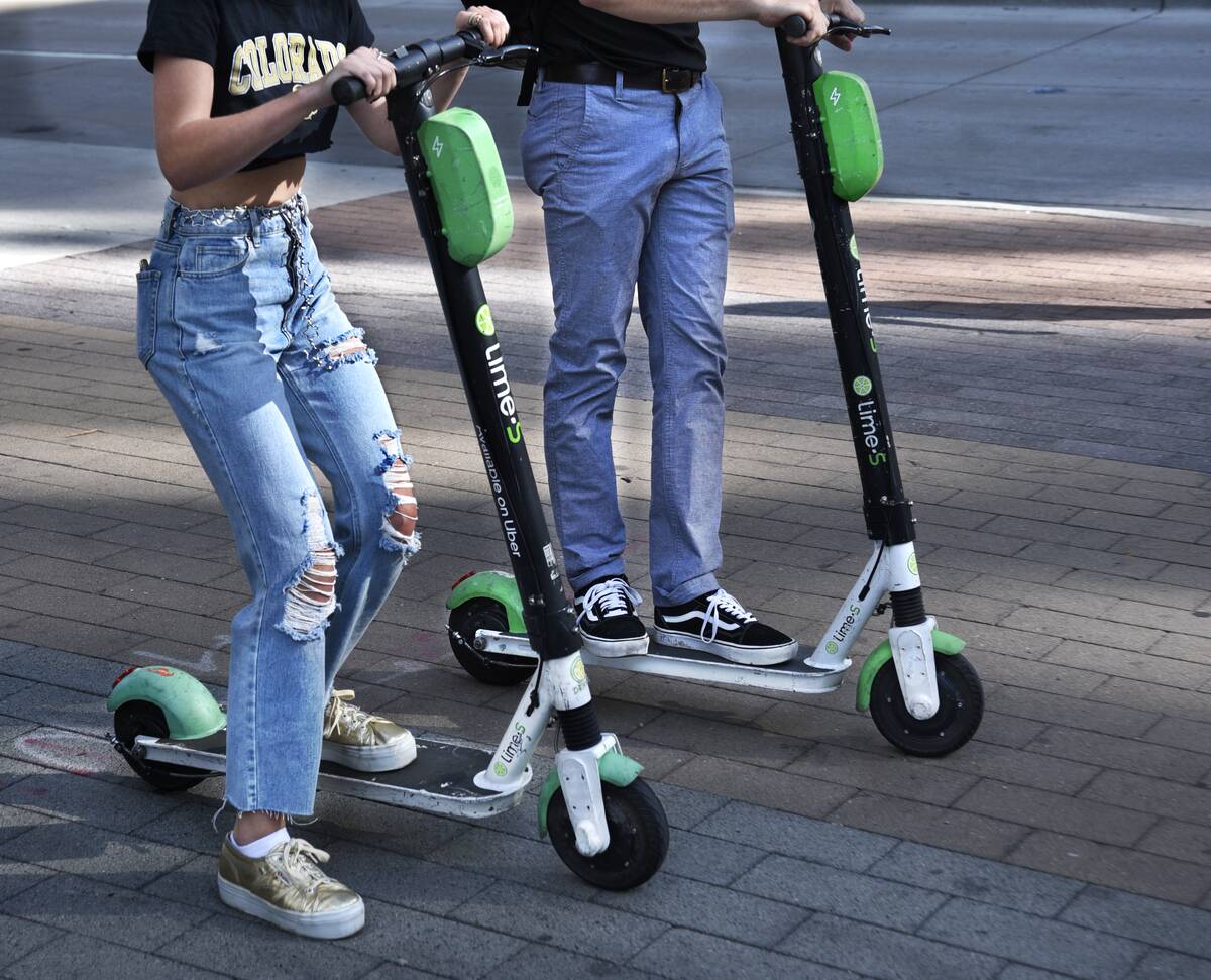 Teenagers ride rented electric scooters