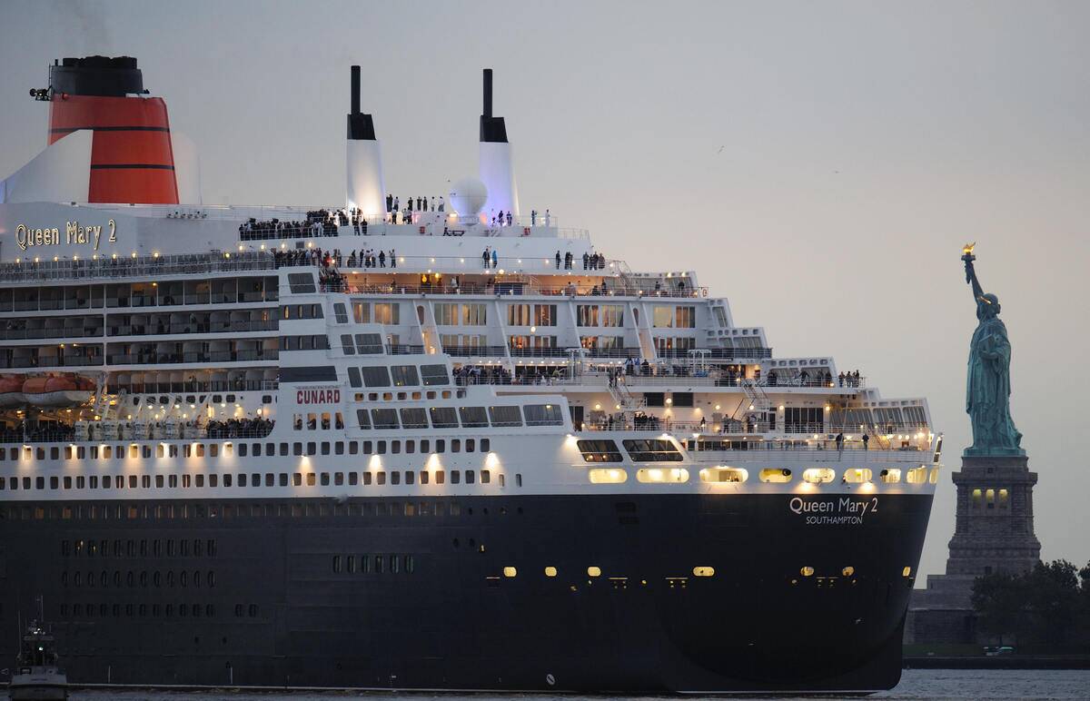 The Queen Mary 2 sails near the Statue