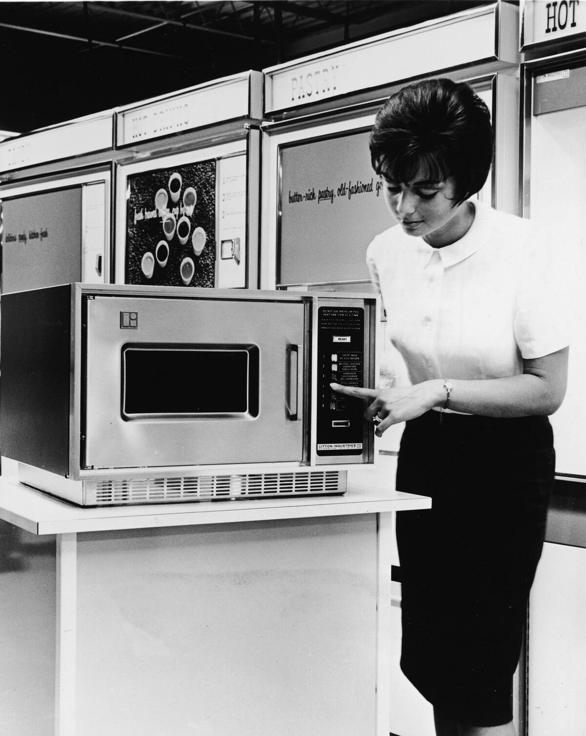 Woman Demonstrates Microwave Oven