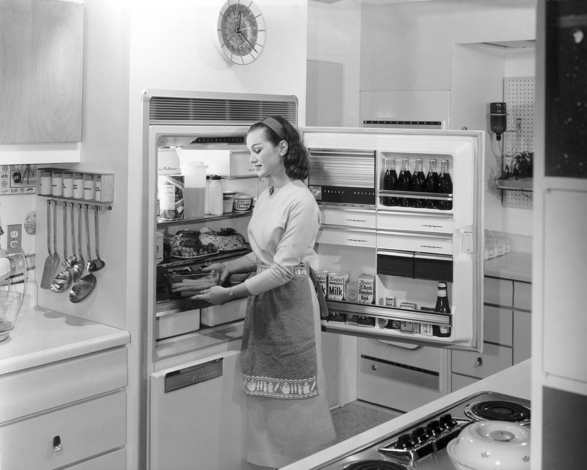 Woman Placing Food Into Refrigerator