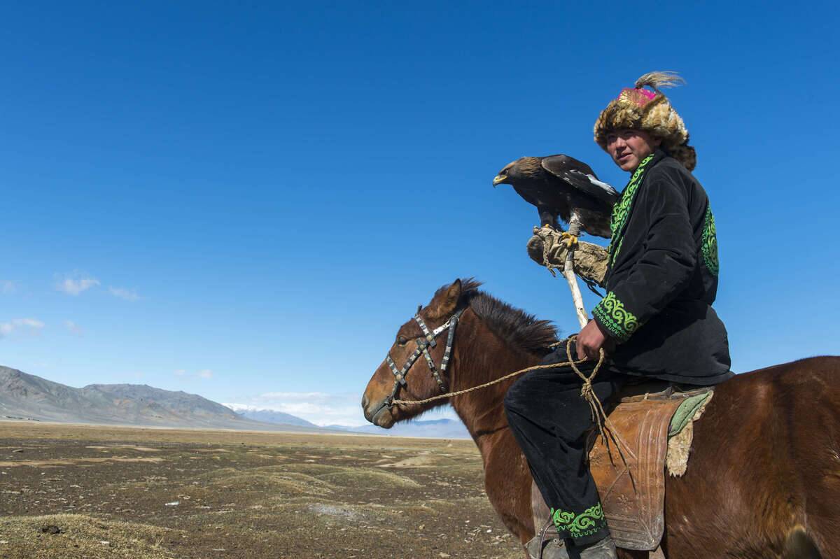 A Kazakh eagle hunter on horseback with his Golden eagle (...