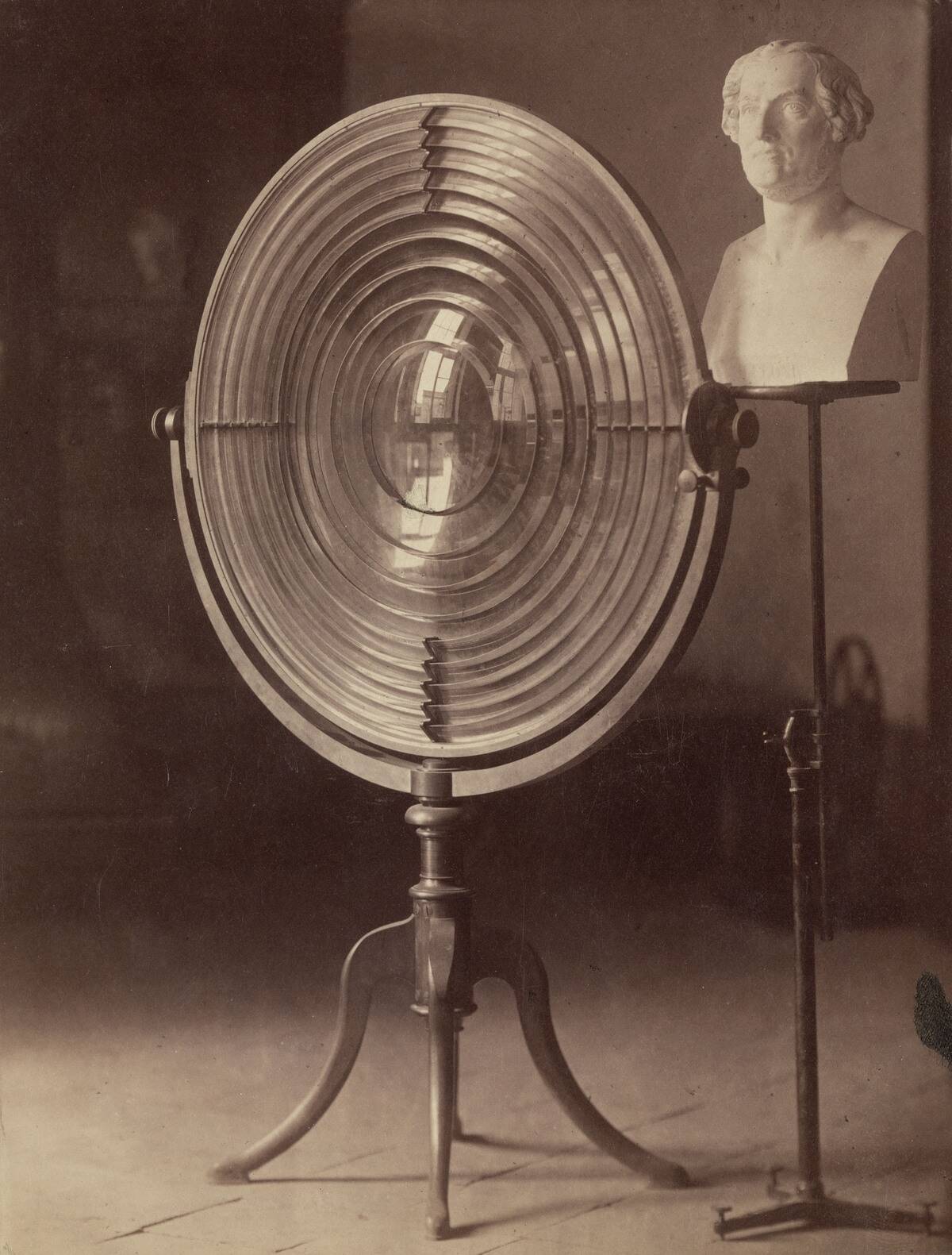 Fresnel lens used by Melloni and a bust of Melloni, 1876.