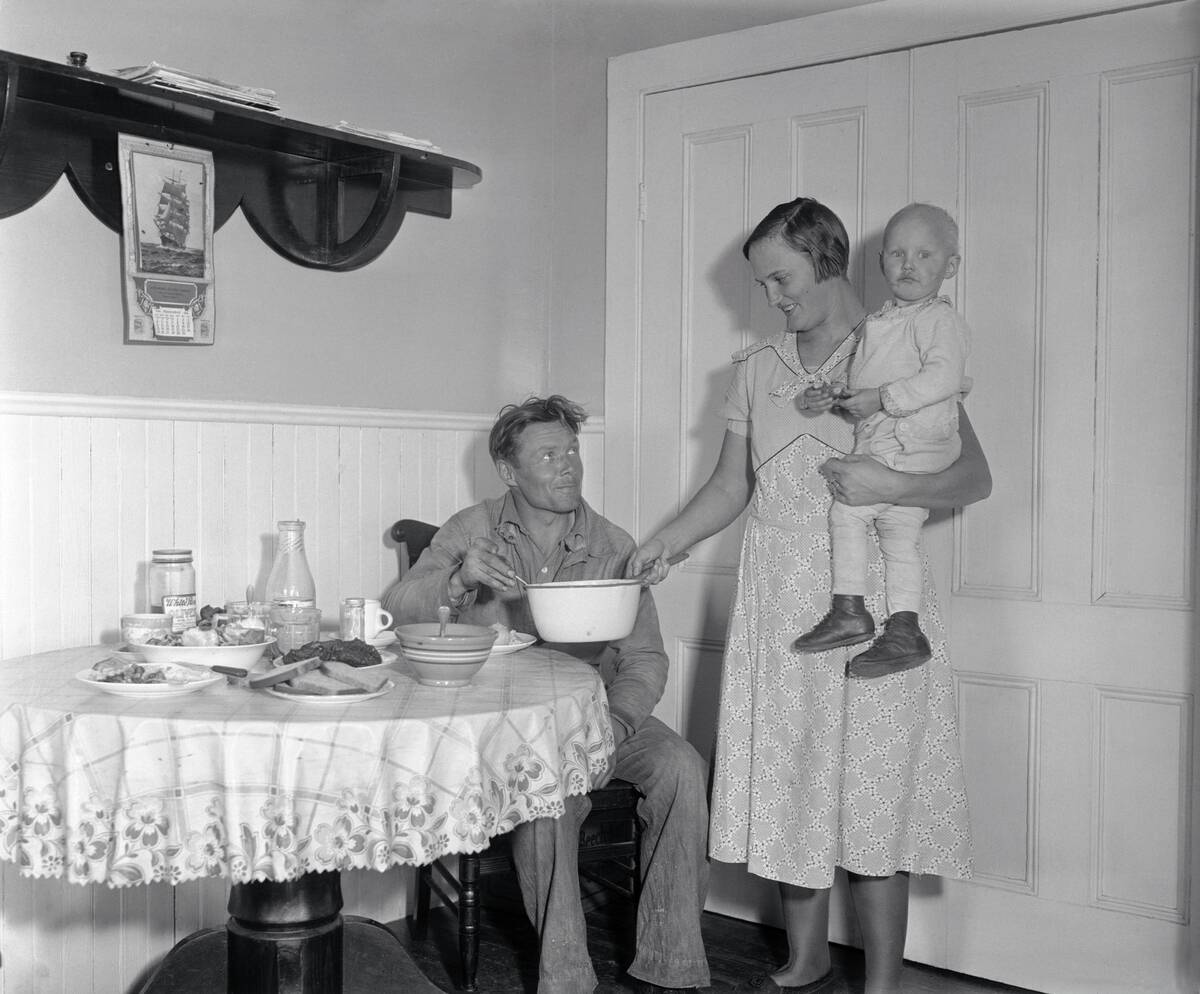 Mrs. Gus Axelson Serving a Meal to Her Husband