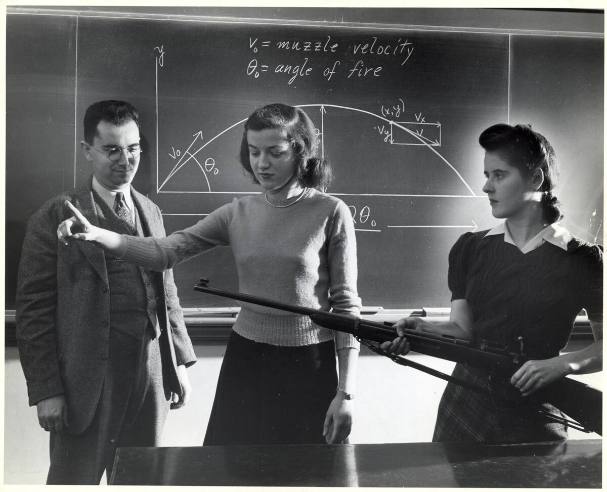 Women Students W/Rifle At Blackboard