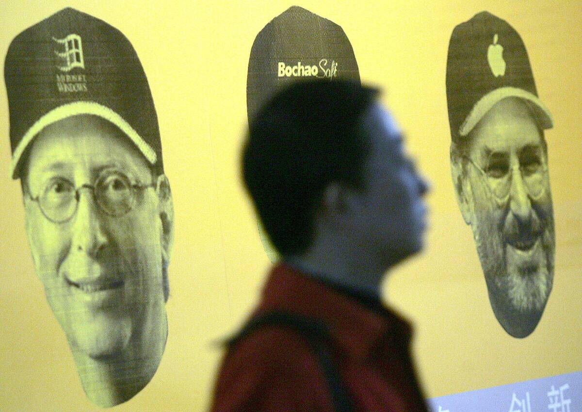 A Chinese jobseeker walks pass a poster...