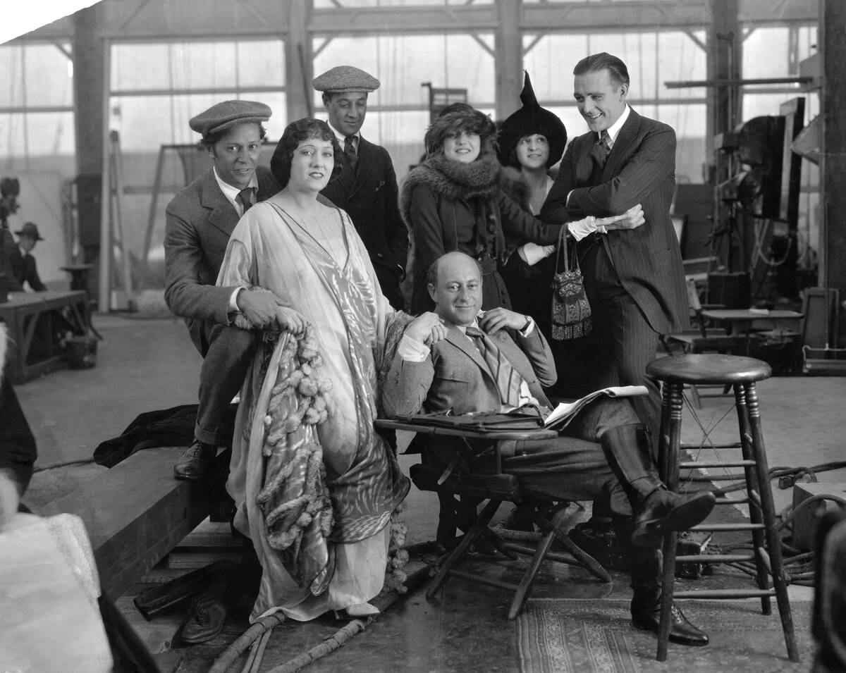 Director Cecil B. DeMille Surrounded by Actors