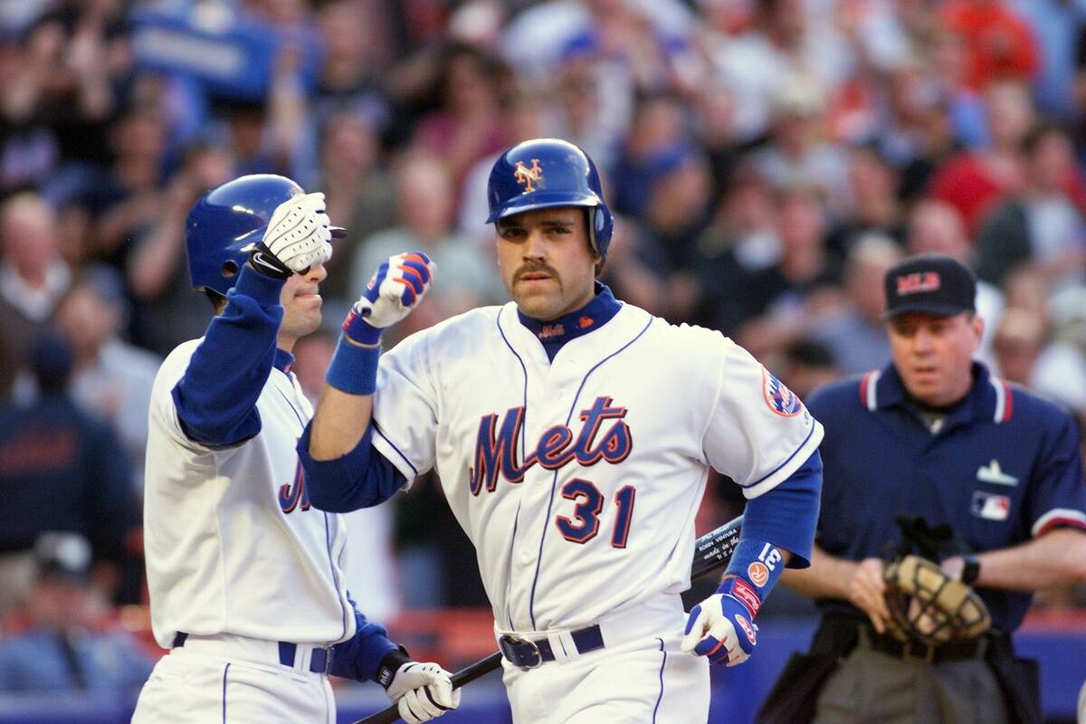 New York Mets' Mike Piazza gets congratulated by teammate Ro