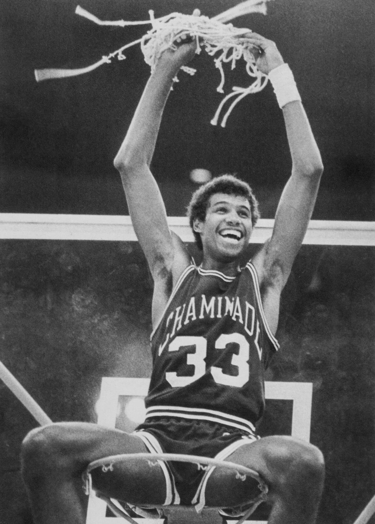 Richard Haenisch Holding Net atop Basketball Hoop