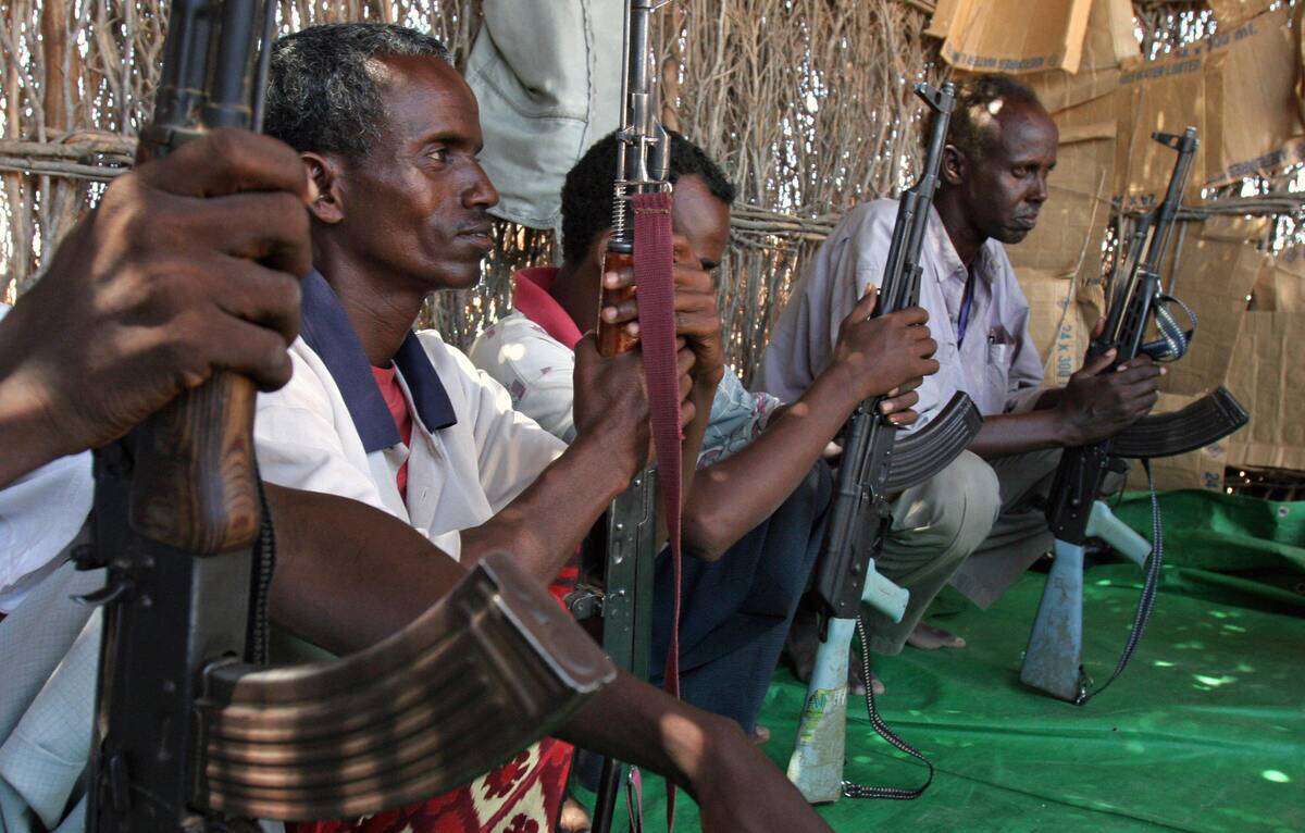 Somalian gunmen sit in shade in the sout