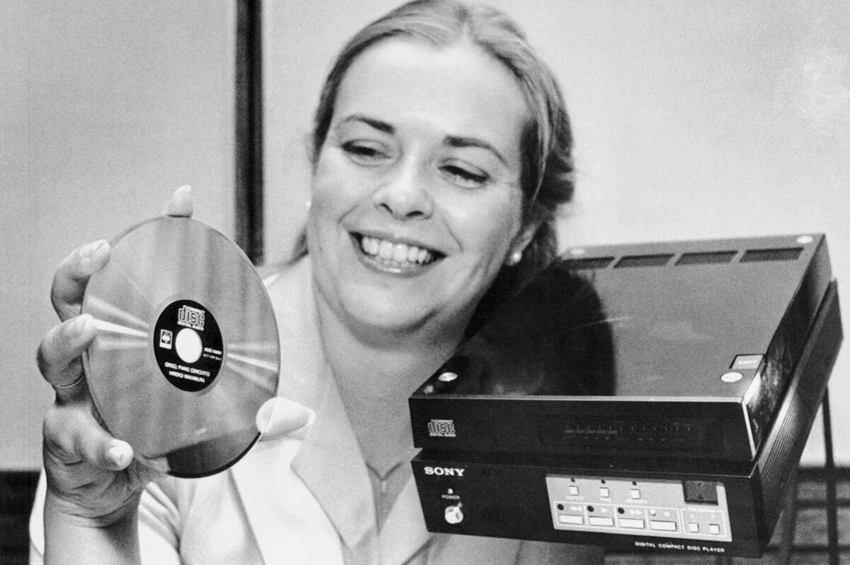 Woman Displaying Compact Disc and Player