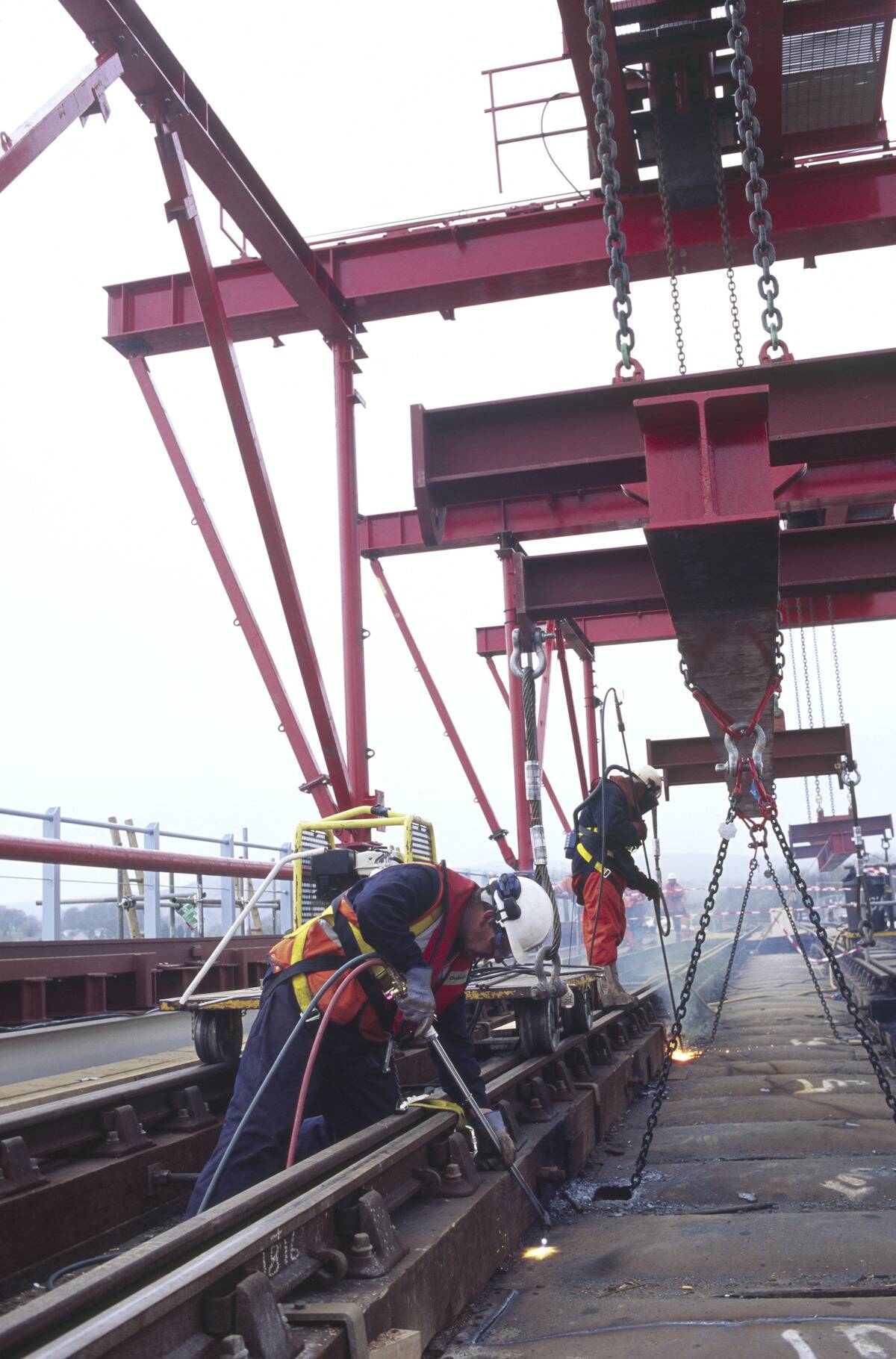 Burning through old corroded steel base of a rail bridge in north Morecombe bay using accetylene and thermic lances for a renovation project, England, UK