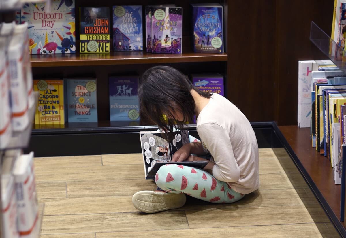 Child read a book at an airport bookstore
