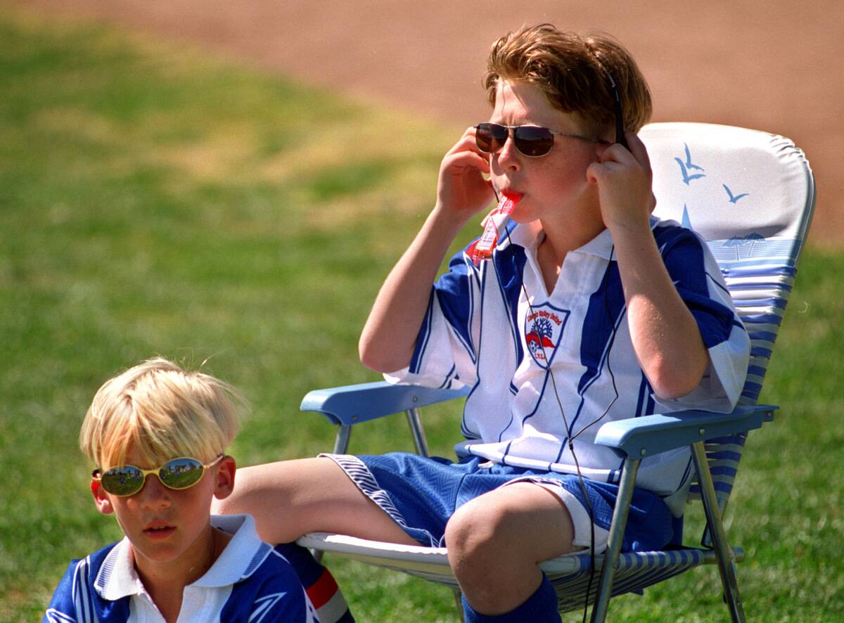 Ryan Boring, 10, right, adjusts the headphones connected to his casette tape recorder while listenin