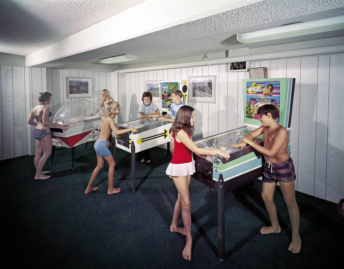 Teens Playing Pinball in Hotel Game Room