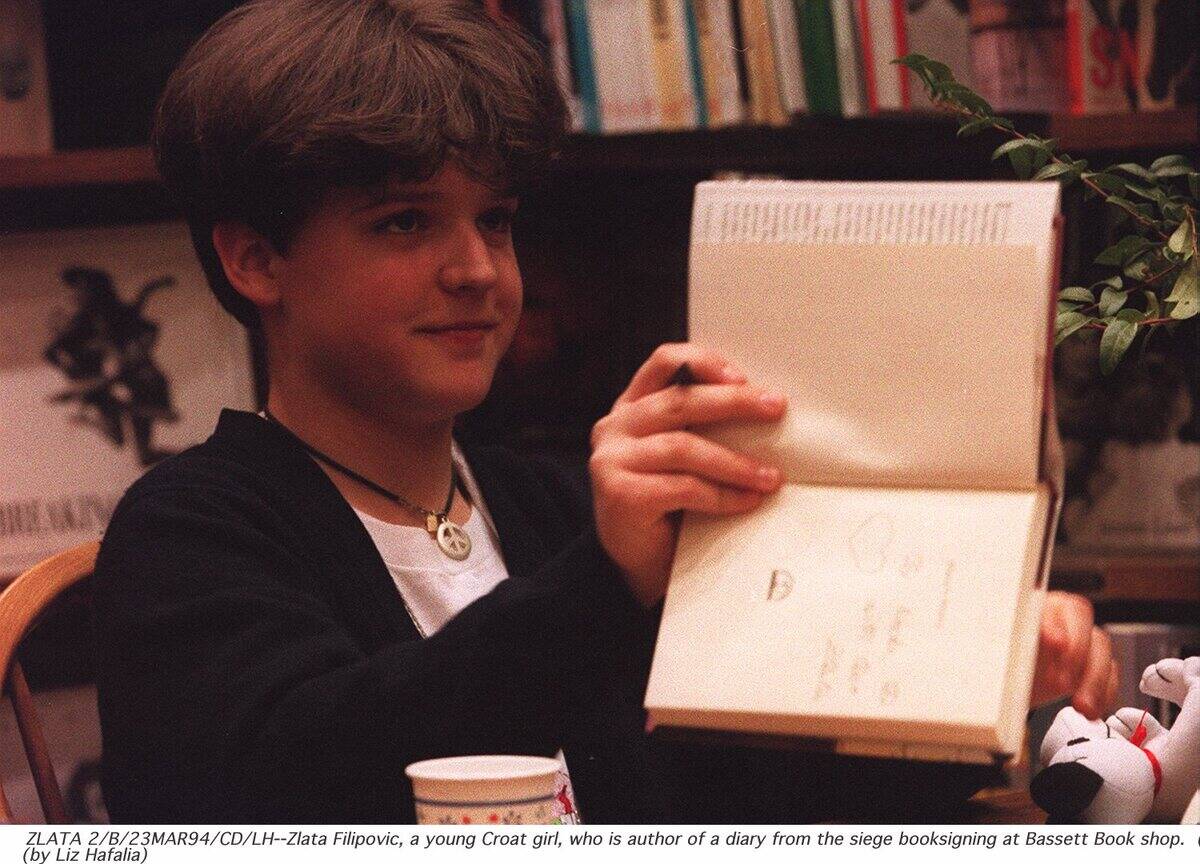 ZLATA FILIPOVIC SIGNS COPIES OF HER BOOK, A DIARY OF HER LIFE DURING THE SIEGE OF SARAJAVO, AT BASSET BOOK SHOP
