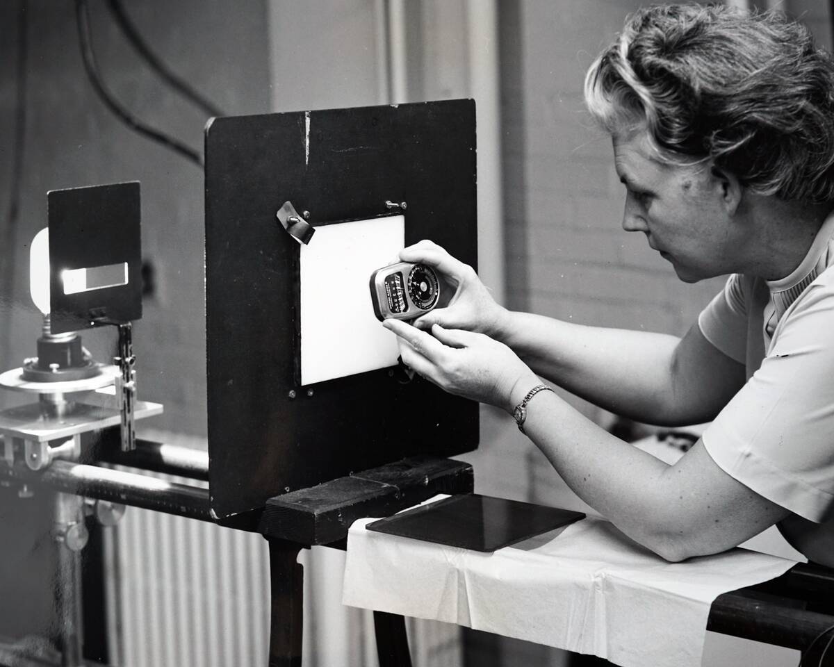 A female scientist measuring light with a light meter.