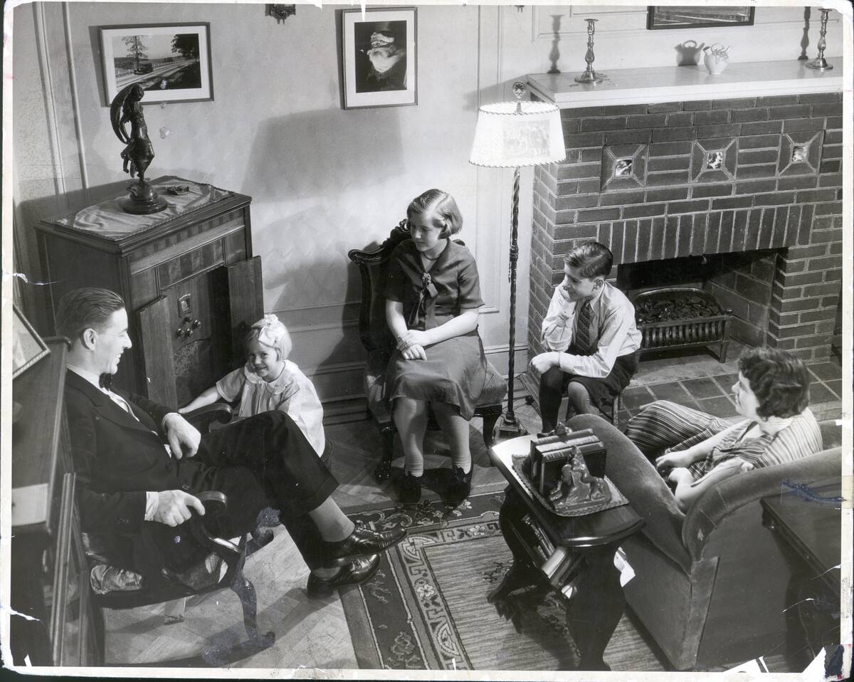 Family Seated in Living Room Around Radio