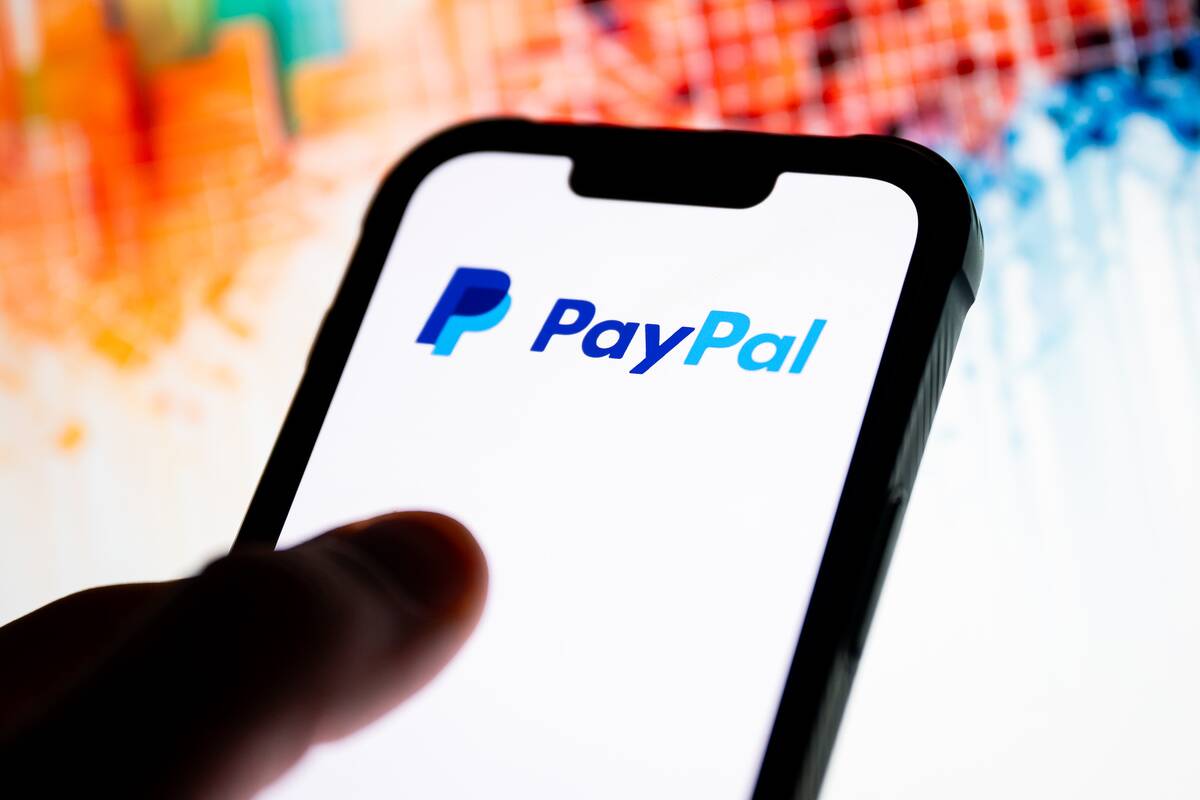 In this photo illustration, a PayPal logo seen displayed on...