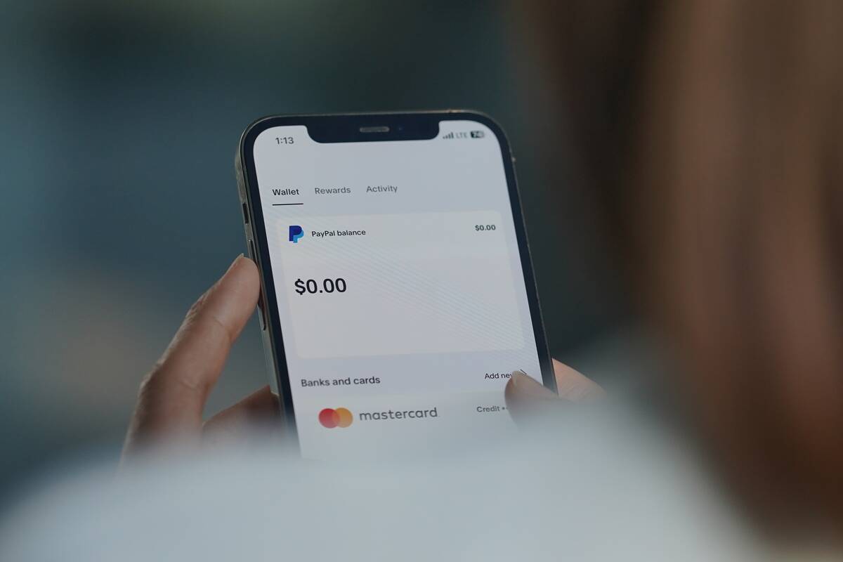 In this photo illustration, A woman browses the Paypal APP...