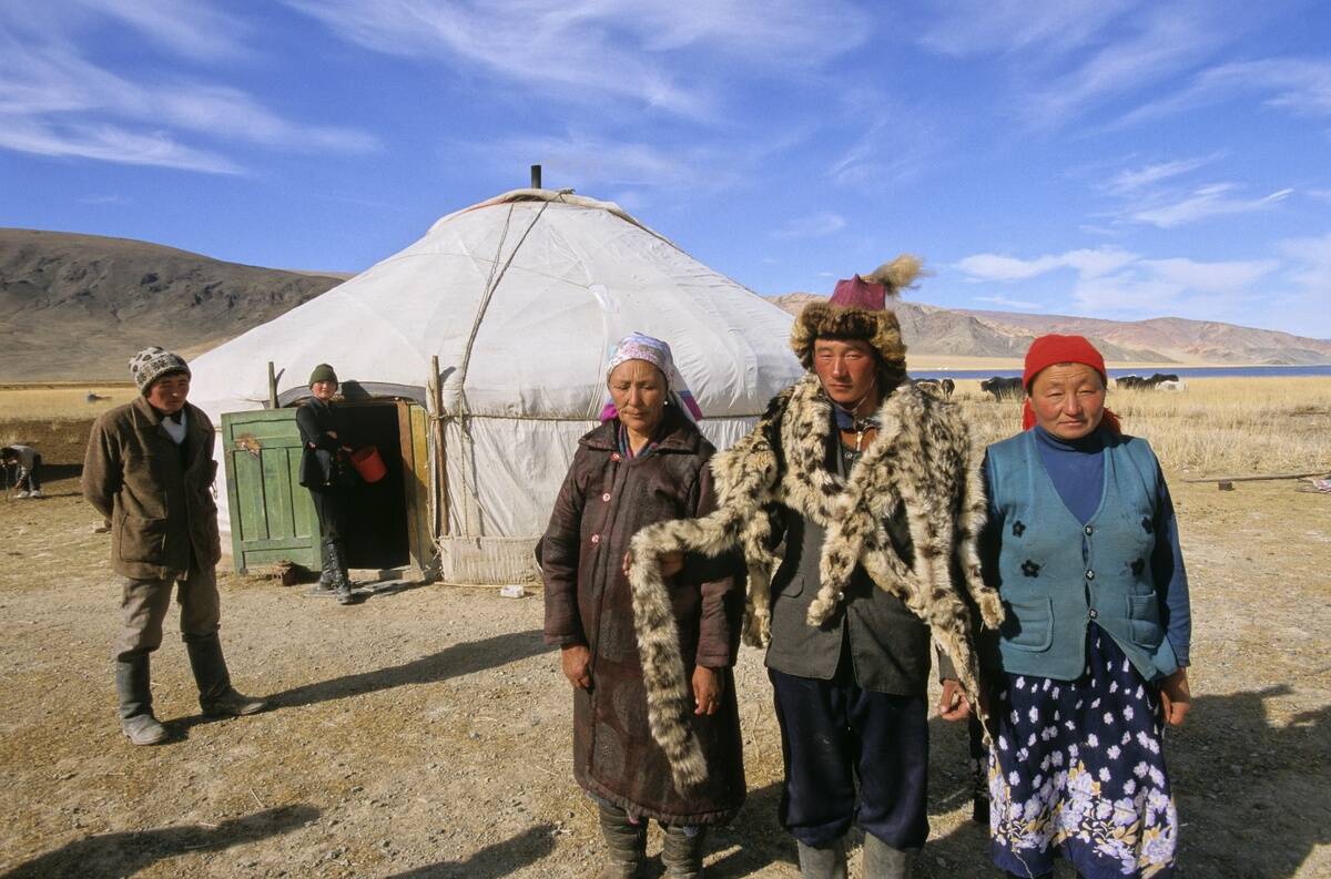 KAZAKH FAMILY SHOWING A SNOW LEOPARD SKIN, MONGOL YURT, ALTAI RANGE, BAYAN OLGII PROVINCE, MONGOLIA