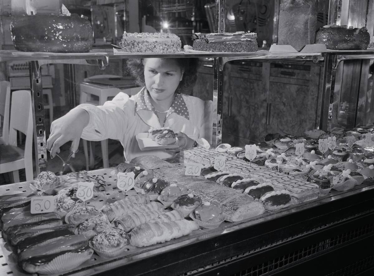 Woman Selecting French Pastries from Display