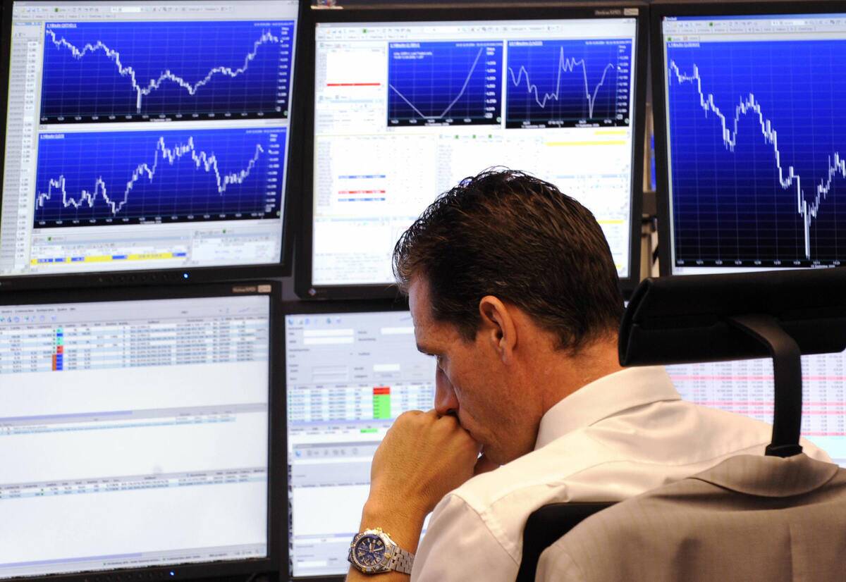 A broker looks at his screens at Frankfu