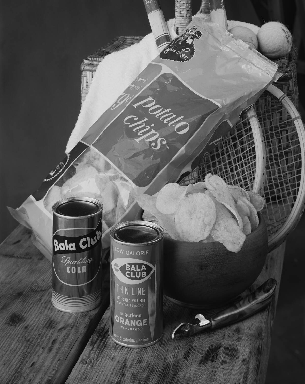 Chips and drinks can with sports equipment on table