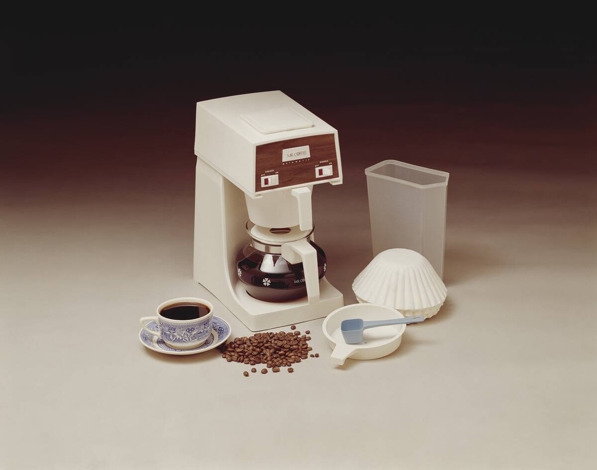 Coffee maker with coffee cup and beans