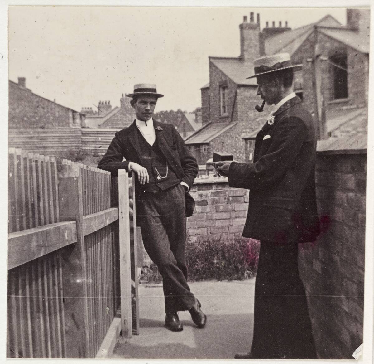 Man taking a photograph with a Brownie camera, c 1900.