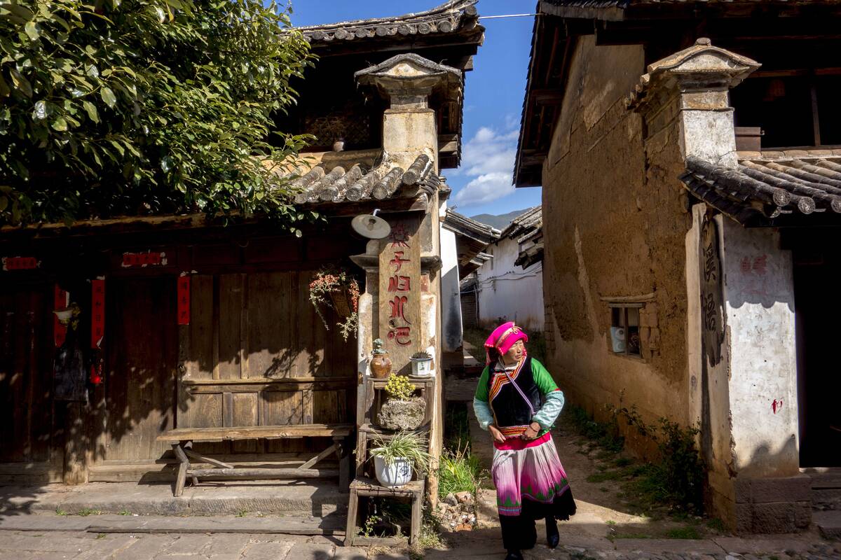 Minority ethnic woman walks in the ancient alley leading to...