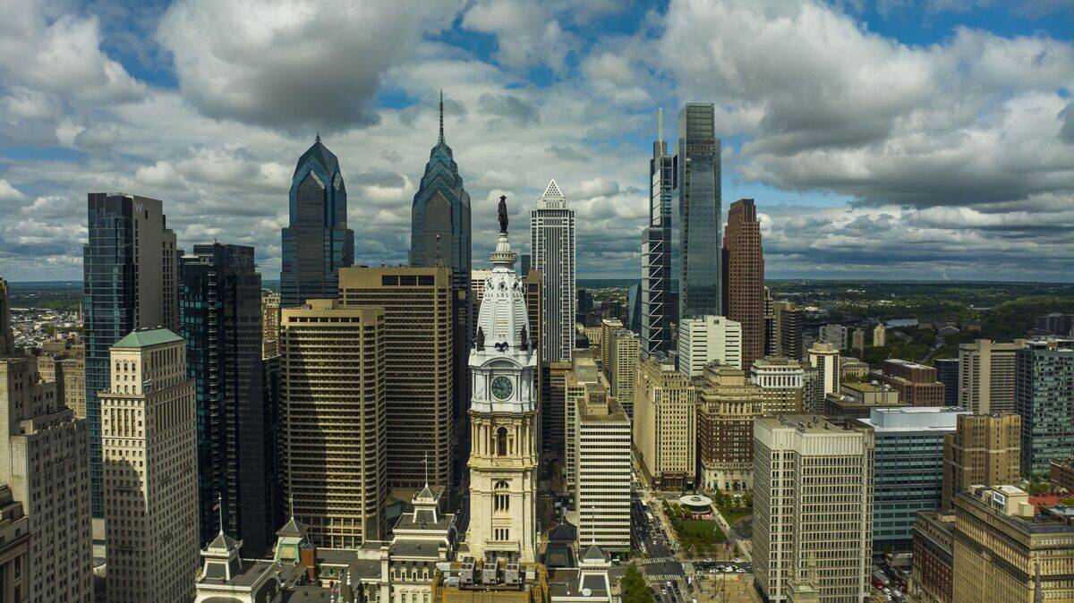 Philadelphia skyline with white puffy clouds focusing on William Penn Statue Broad Street area, Pennsylvania