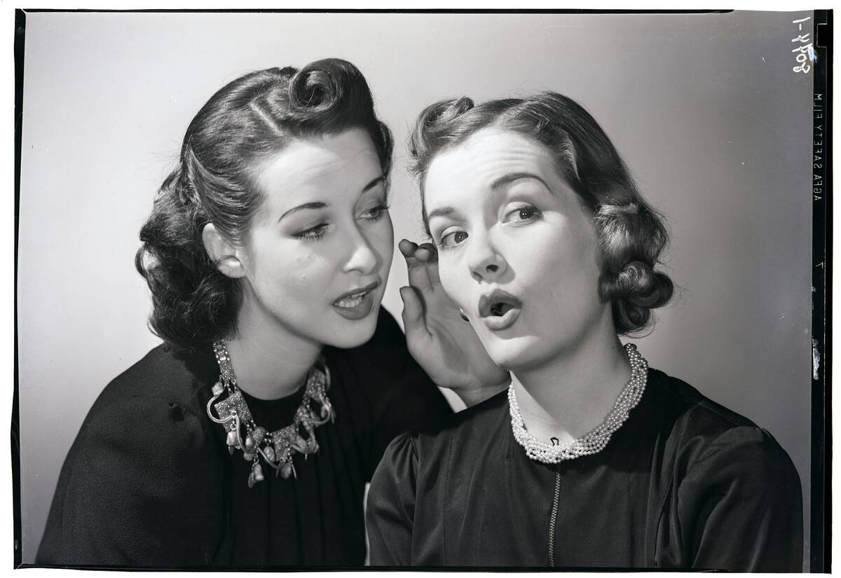 Woman Whispering in Friend's Ear