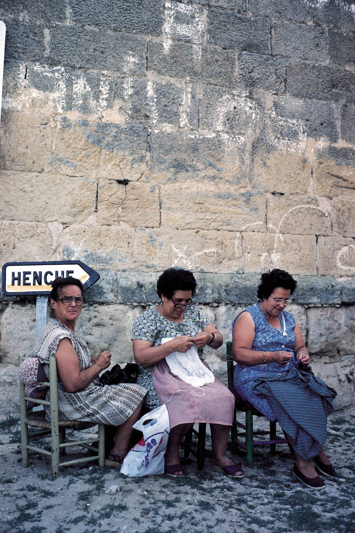 Women of Solanillos del Extremo. Guadalajara Three women of the village sewing and knitting seated with their seats in the street