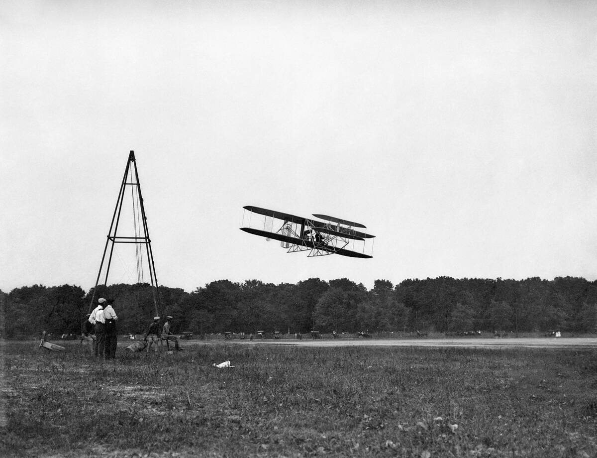 Wright Bros' Airplane Flying Past Men
