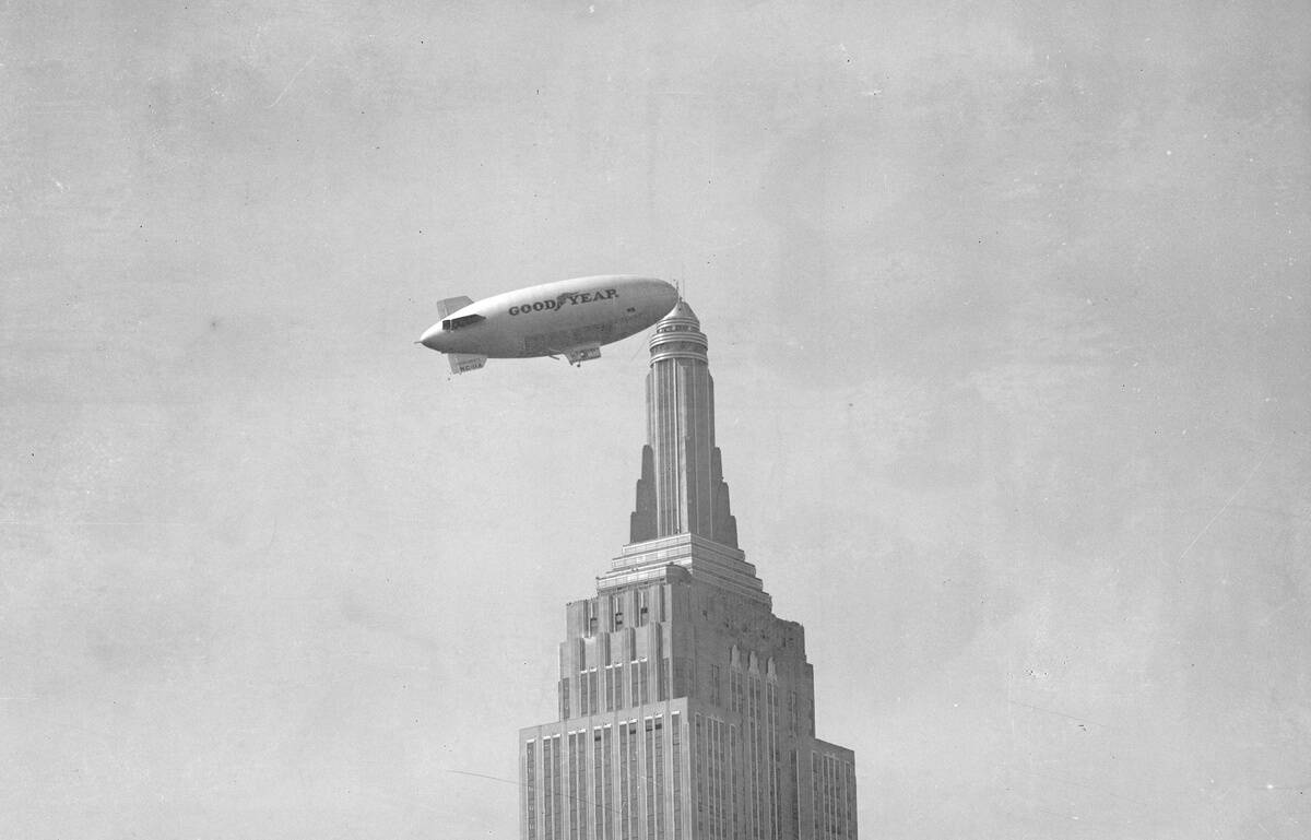 Goodyear blimp flies near the Empire State Building.